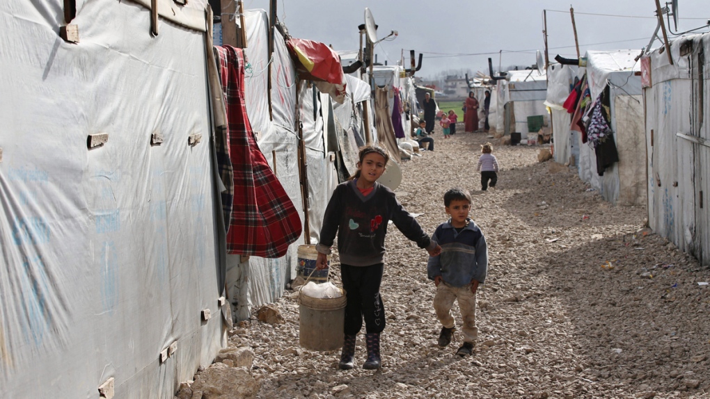 Syrian children walk between their tents at a refugee camp in Deir Zannoun village, Bekaa valley, Lebanon, on Jan. 6, 2015.