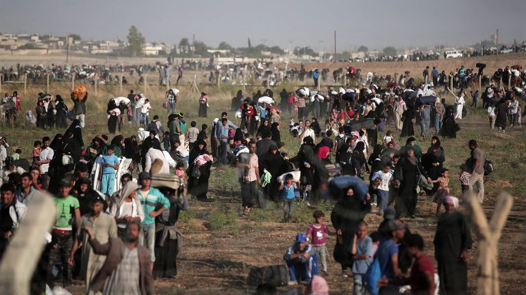 Thousands of Syrian refugees walk in order to cross into Turkey in Akcakale, Sanliurfa province, southeastern Turkey.